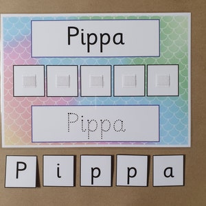 May include: A learning aid featuring the name "Pippa" in large print, dotted print, and individual letter tiles. The background has a mermaid scale pattern in pastel colors. Five squares are above the dotted name.