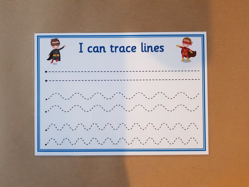 May include: A white tracing worksheet with blue borders and the text "I can trace lines." The worksheet features dotted lines in various patterns, with superhero illustrations at the top. Great for early childhood education and fine motor skills.