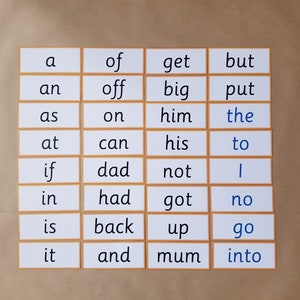 May include: A set of flashcards with sight words printed in a black font, with the word "the" and "go" in blue. The cards are arranged in a grid pattern with a light brown border, set against a light brown background.