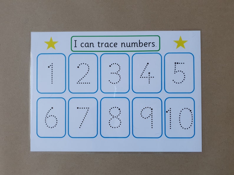May include: A white educational card with blue borders, featuring numbers 1-10 in dotted lines for tracing. The text "I can trace numbers" is above the numbers, with yellow stars on each side. Educational material for children.