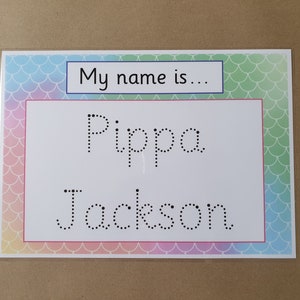 May include: A name tag with a colorful mermaid scale border. The tag has the text "My name is..." in a blue box, and the name "Pippa Jackson" in dotted letters for tracing.