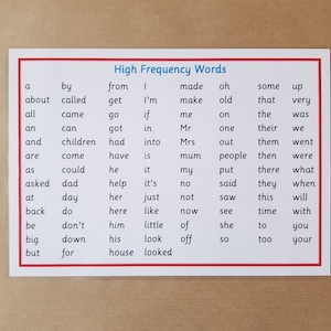 May include: A white card with a red border lists "High Frequency Words" in black text, ideal for educational purposes. The words are organised in columns. The card is displayed on a light brown surface.