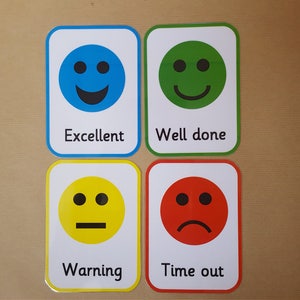 May include: Four cards with rounded corners, each displaying a different emoji and text. The emojis are a smiling blue face labelled "Excellent", a smiling green face labelled "Well done", a yellow face labelled "Warning", and a sad red face labelled "Time out".