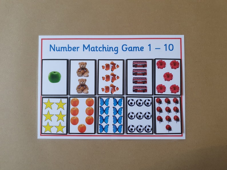 May include: A number matching game for children, featuring cards with illustrations of objects representing numbers 1-10. Includes a green apple, teddy bears, clownfish, red buses, flowers, stars, oranges, butterflies, soccer balls, and ladybugs.