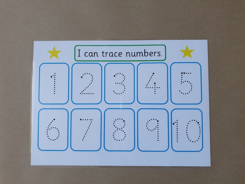 May include: A white educational card with blue borders and the text "I can trace numbers." Features numbers 1-10 in dotted lines for tracing practice. Includes yellow star accents.