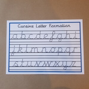 May include: A rectangular white educational worksheet titled Cursive Letter Formation in black text. It features three rows of black dotted lowercase letters from a to z, arranged on horizontal lines within a blue border for handwriting practice.