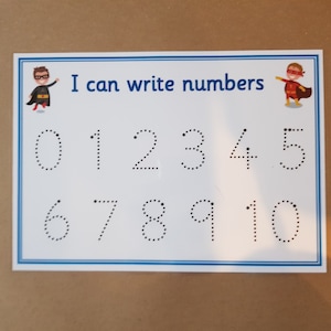 May include: A white educational card with a blue border, featuring the text "I can write numbers." Numbers 0-10 are displayed as dotted lines for tracing. Cartoon superheroes are in the corners.