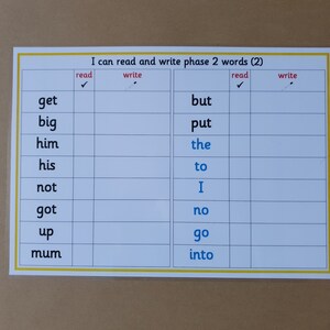 May include: A white laminated educational chart with the text "I can read and write phase 2 words (2)". The chart is divided into columns for reading and writing words, with a list of words such as "get", "big", and "but".