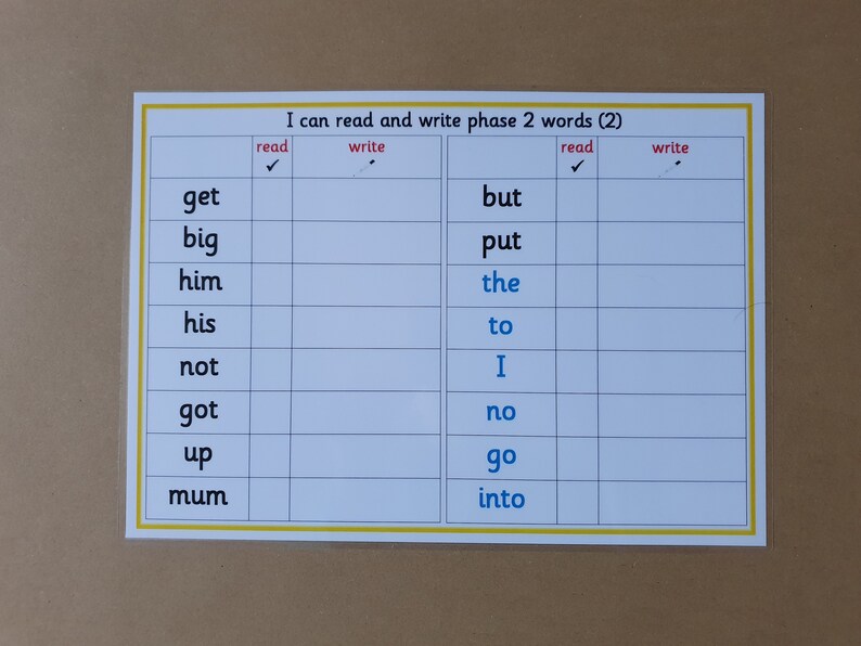 May include: A white laminated educational chart with the text "I can read and write phase 2 words (2)". The chart is divided into columns for reading and writing words, with a list of words such as "get", "big", and "but".