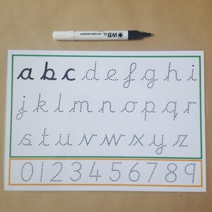 May include: A white sheet with the alphabet and numbers in dotted lines for tracing, with a green and orange border. A black and white marker is at the top. The letters are in lowercase, and the numbers are from 0 to 9.
