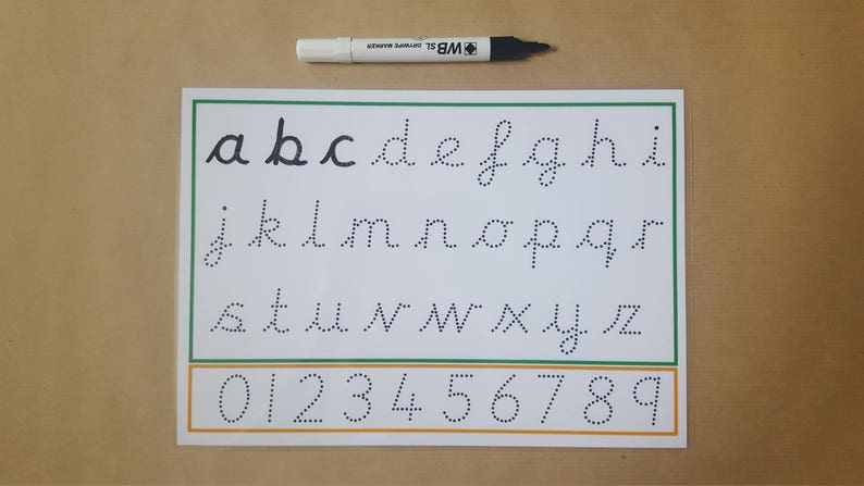 May include: A white and green alphabet and number tracing worksheet with dotted letters and numbers. A black and white marker is above the worksheet. The worksheet includes lowercase letters a-z and numbers 0-9.