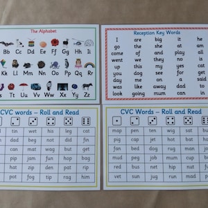 May include: Four educational flashcards with text and illustrations. The cards include the alphabet, key words, and CVC (consonant-vowel-consonant) words for early reading practice. The cards are white with colorful borders and text.