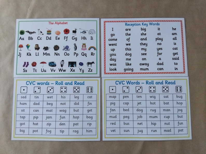 May include: Four educational flashcards with text and illustrations. The cards include the alphabet, key words, and CVC (consonant-vowel-consonant) words for early reading practice. The cards are white with colorful borders and text.