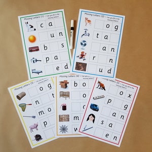 May include: A set of educational flashcards for children, with the text "Missing Letters" and pictures to aid spelling. The cards are designed to help kids learn to spell. A whiteboard marker is also included.