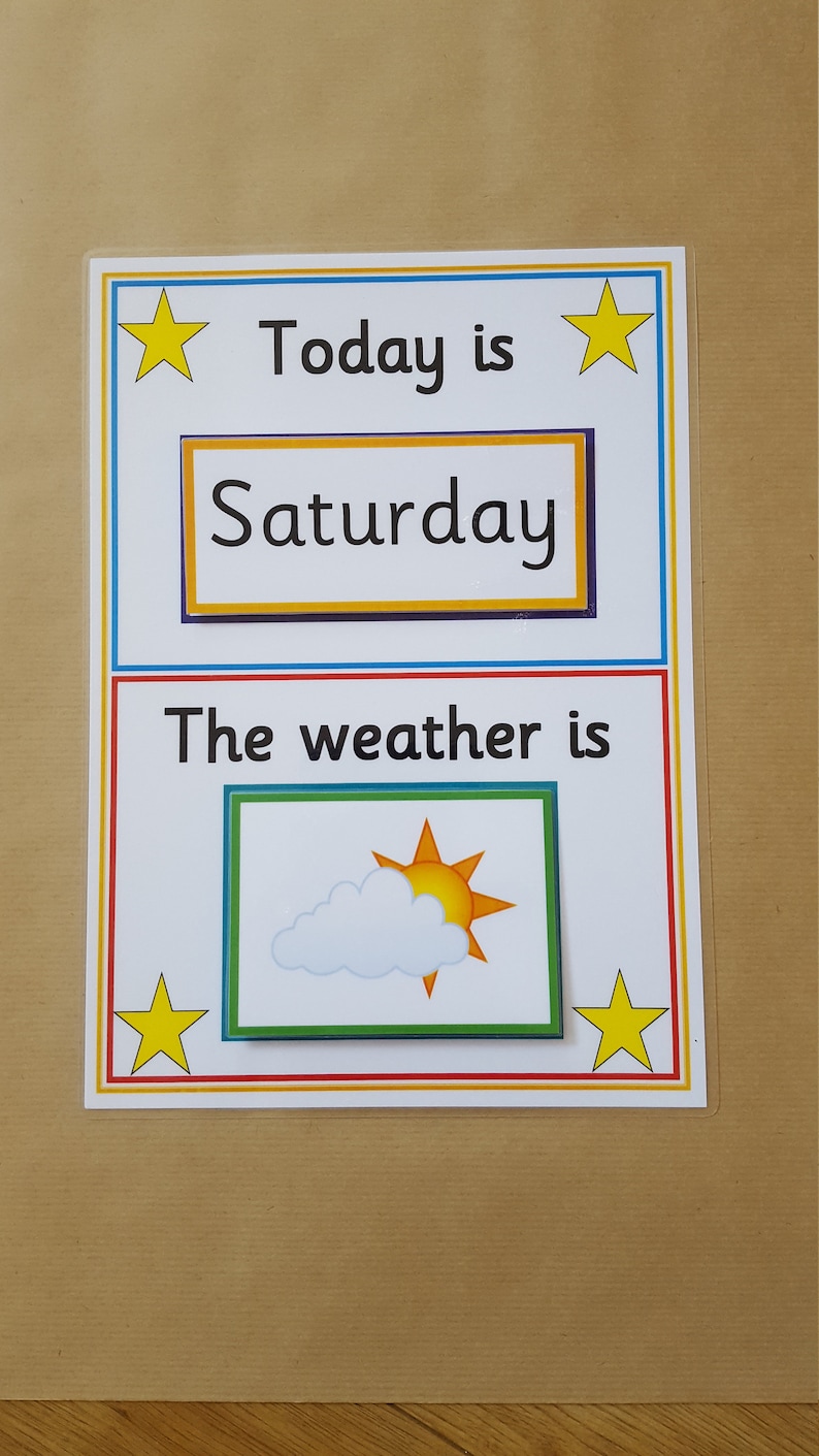 May include: A laminated educational chart with the text "Today is Saturday" and "The weather is." The weather section shows a sun and cloud graphic. Yellow stars and colorful borders frame the text.