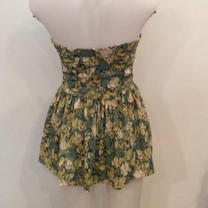May include: A green and white floral halter top dress with a ruffled skirt.
