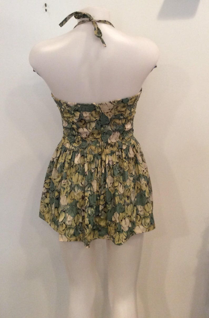 May include: A green and white floral halter top dress with a ruffled skirt.