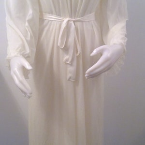 May include: A white sheer robe with a floral lace collar and long sleeves. The robe has a sash tie at the waist.