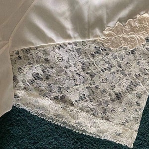 May include: White lace trim with a delicate floral pattern. The lace is soft and flowing, and it would be perfect for adding a touch of elegance to any project.