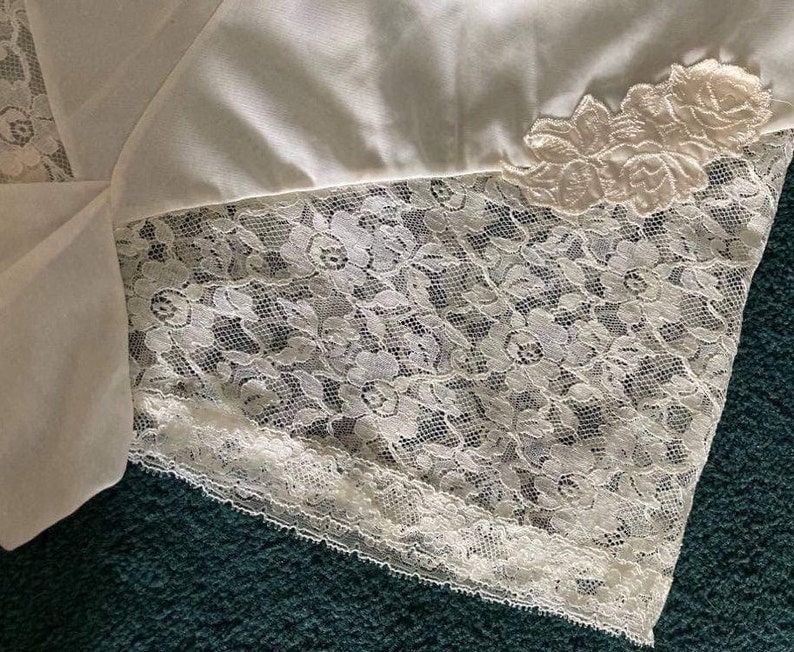 May include: White lace trim with a delicate floral pattern. The lace is soft and flowing, and it would be perfect for adding a touch of elegance to any project.