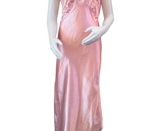 May include: A pink satin nightgown with a lace trim and a bow at the neckline.