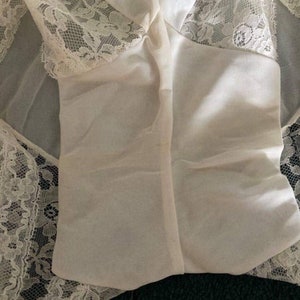 May include: White lace lingerie with a sheer overlay and a delicate floral pattern.