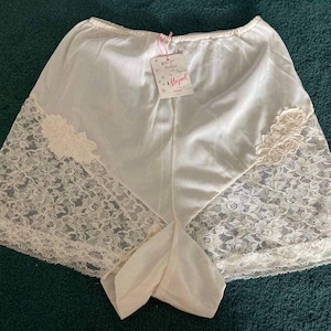 May include: White lace trimmed nylon underwear with a pink label that says "Magical" on it.