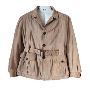 May include: Tan corduroy jacket with a belted waist, button closure, and two front pockets. The jacket has a classic collar and long sleeves. The jacket is displayed on a white mannequin.