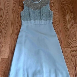 May include: A light blue sleeveless dress with a lace bodice. The dress has a fitted bodice and a full skirt.