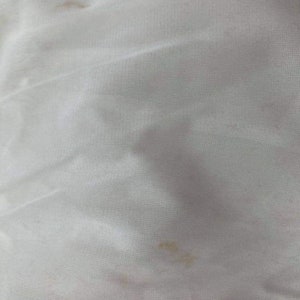 May include: White fabric with two small brown stains.