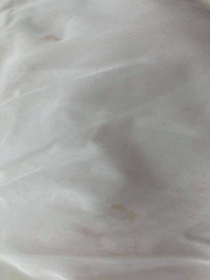 May include: White fabric with two small brown stains.