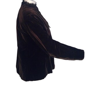 May include: A brown velvet jacket with a black lace collar. The jacket has long sleeves and a fitted silhouette.