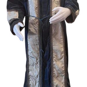 May include: A long, blue velvet robe with white satin panels and gold trim. The robe has a sash and a tassel.