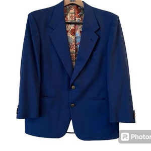 May include: A blue blazer with a patterned lining. The blazer has two button closures and two pockets.