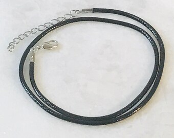 May include: A black cord necklace with a silver clasp.