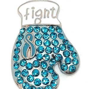 May include: Silver charm in the shape of a boxing glove with blue rhinestones and the word "fight" on the top. The glove has a blue ribbon with a number 8 on it.