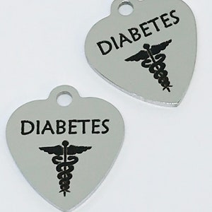 May include: Two silver heart-shaped charms with the word "DIABETES" and a medical caduceus symbol.