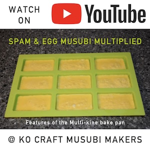 Może przedstawiać: Zielona silikonowa forma z dziewięcioma prostokątnymi wnękami wypełnionymi ż&oacute;łtą mieszanką. Forma znajduje się na szarym tle. Tekst "SPAM & EGG MUSUBI MULTIPLIED" znajduje się nad formą. Tekst "Features of the Multi-kine bake pan" znajduje się pod formą. Tekst "@KO CRAFT MUSUBI MAKERS" znajduje się na dole obrazu.