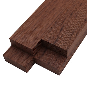 May include: Three pieces of dark brown wood, stacked on top of each other. The wood has a fine grain pattern and a reddish hue.