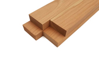May include: Four pieces of unfinished cherry wood, stacked on top of each other. The wood is a light brown color and has a smooth surface.