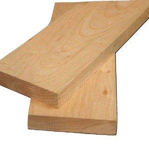 May include: Two pieces of unfinished, light brown wood. The wood is smooth and has a natural grain pattern.