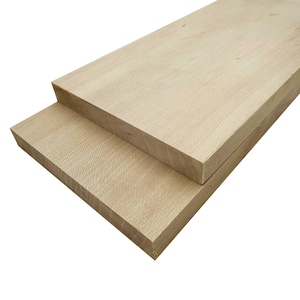 May include: Two unfinished, light-colored wooden planks are stacked on top of each other. The wood grain is visible, and the edges are cleanly cut. The planks appear to be ready for use in a woodworking project.