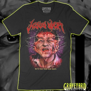 May include: A black short-sleeve t-shirt featuring a graphic of a face with blood and metal hooks. The text JESUS WEPT is printed in red above the graphic, and the text We'll Tear Your Soul Apart is printed in yellow below the graphic.