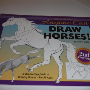 May include: A book cover with the title "Anyone Can Draw Horses!" features a drawing of a rearing horse and a smaller horse. The cover is purple, blue, and yellow, with the text "2nd Edition" in a gold seal.