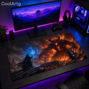 Può includere: Un tappetino da scrivania rettangolare con un'illustrazione fantasy di una figura incappucciata che tiene un bastone con un globo blu luminoso, di fronte a una massiccia creatura demoniaca cornuta e infuocata su un terreno roccioso.