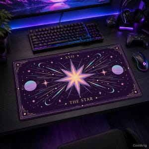May include: A rectangular purple gaming mouse pad featuring a celestial design with a central starburst, planets, and the text "THE STAR" and "XVII". The pad has a gold border and is surrounded by a keyboard, mouse, and other gaming accessories.