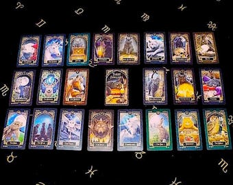 May include: Tarot card spread with 16 cards laid out on a black surface. The cards feature illustrations of animals, including cats, owls, deer, and wolves. The cards are arranged in a grid pattern with the words "Tarot Familiars" printed on one of the cards.