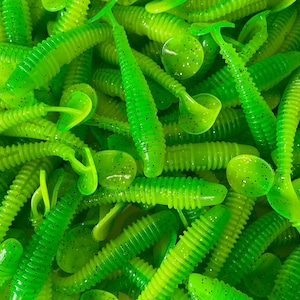 May include: A bulk bag of green and yellow soft plastic fishing lures. The lures have a ribbed texture and a small, round head.