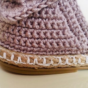 May include: A pair of beige crochet espadrille sandals with a white jute sole.