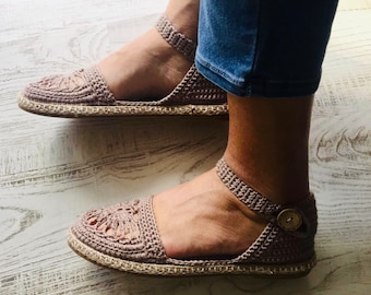 May include: A pair of crocheted sandals with a beige jute sole. The sandals have a delicate, lacy design and are perfect for warm weather.